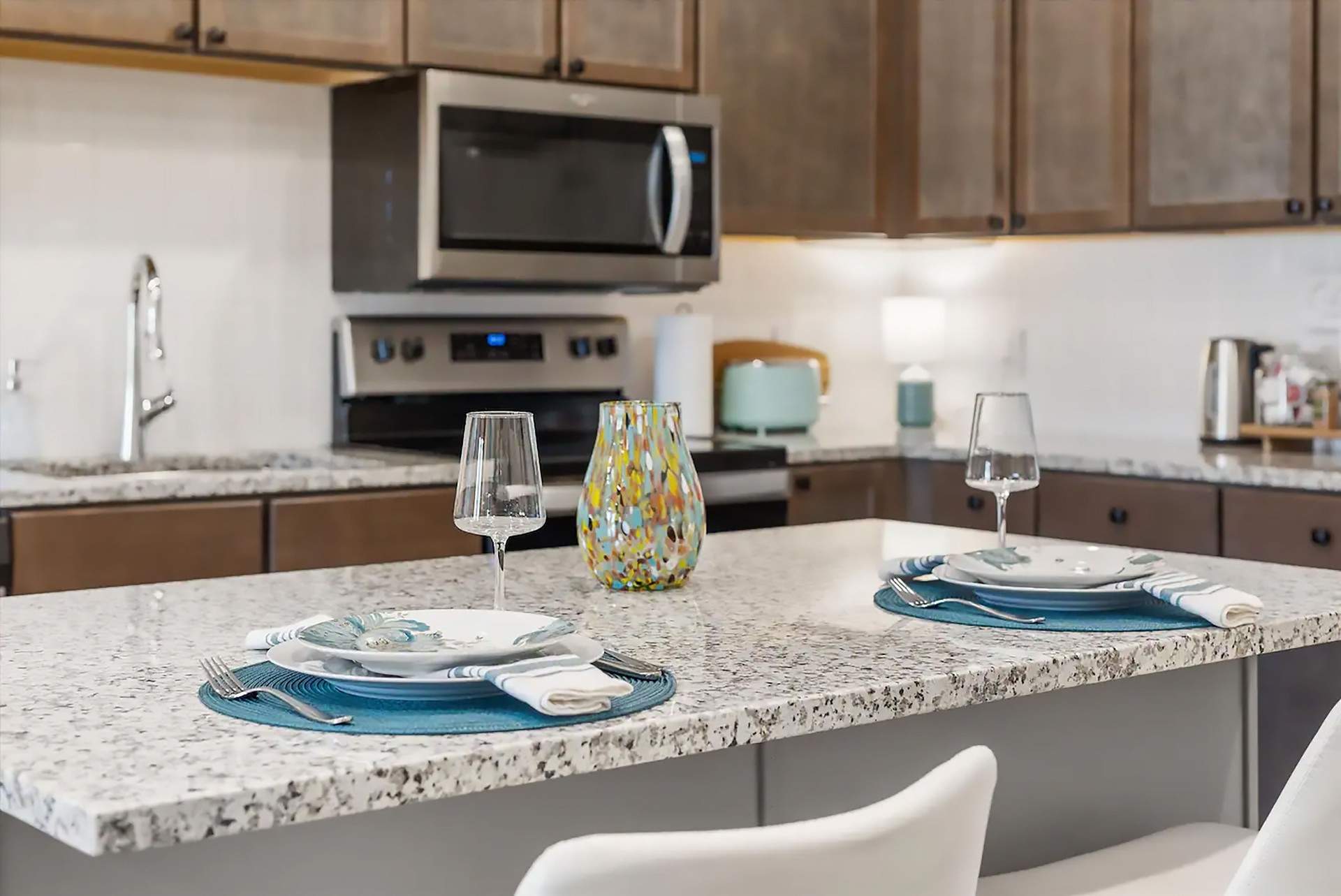 Close up of granite island kitchen counter with place settings for meal